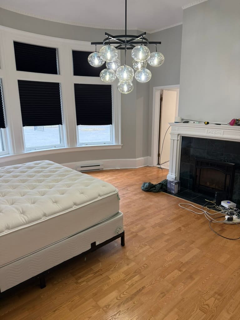 A bedroom in the turret with a bay window and a fireplace